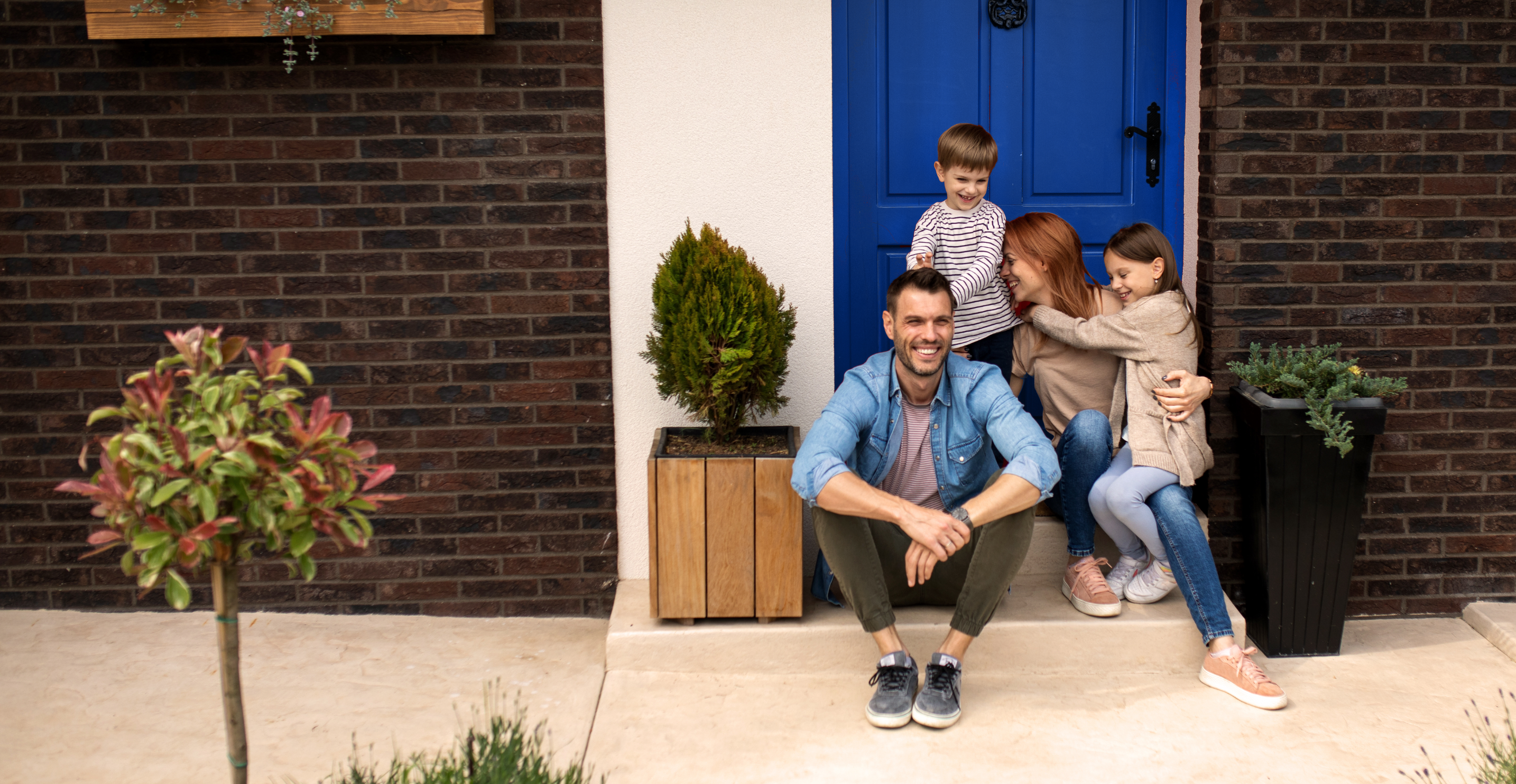 Family sitting in front of home